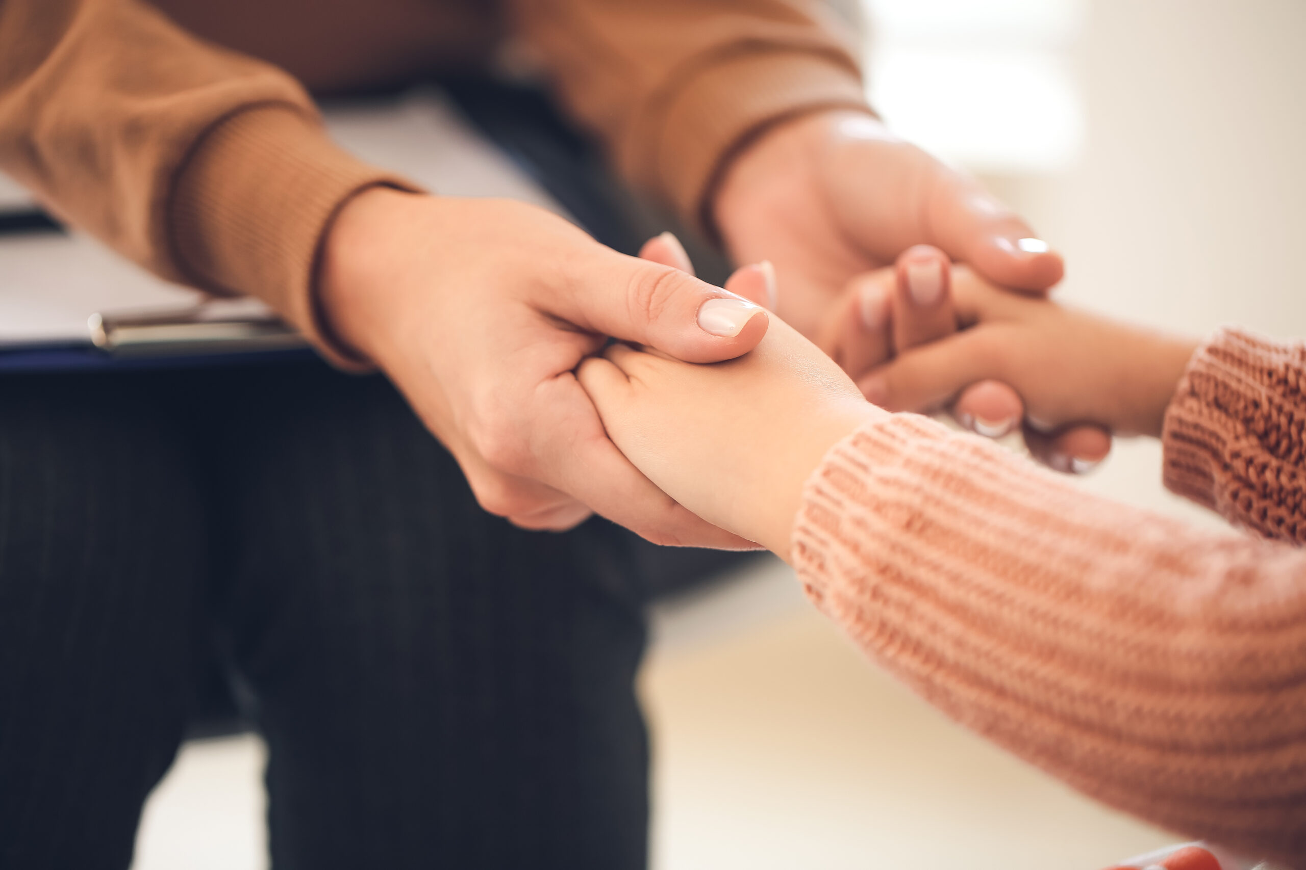 Female psychologist calming little girl during session