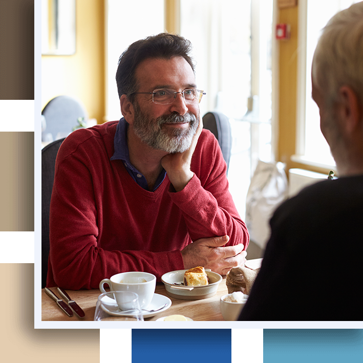A middle aged gay male couple having lunch in a restaurant